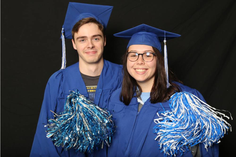 two people use pom poms for a picture